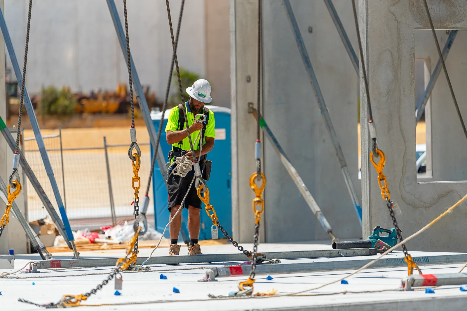 a man in safety gear standing next to a large freshly erected concrete panel